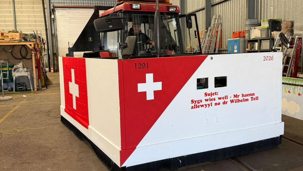 Roter Traktor, der tags&uuml;ber auf einem Acker arbeitet und D&uuml;nger verspr&uuml;ht.